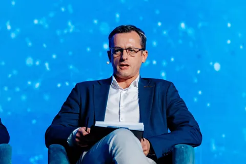 Alexander Morari moderating with a headset microphone and notes at PropTech Connect Europe 2026 in London.