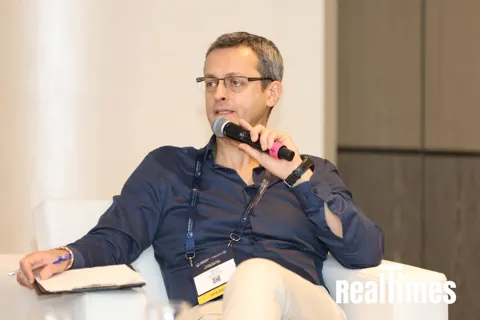 Alexander Morari speaking into a handheld microphone at PropTech Connect Middle East 2026 in Dubai.
