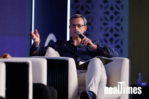 Alexander Morari gesturing as he moderates on the blue stage at PropTech Connect Middle East 2026 in Dubai.
