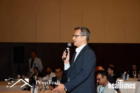 Alexander Morari standing with a handheld microphone at Future PropTech Summit 2025 in Dubai.