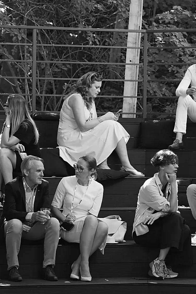 Guests in conversation on the amphitheatre steps at a RealTimes evening in Warsaw