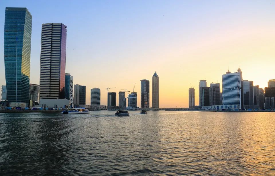 Business Bay towers on the Dubai Water Canal at sunset, a district where floors are sold to many owners